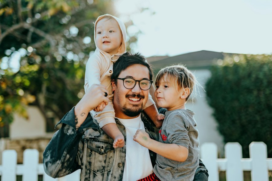 Un père portant ses enfants en souriant